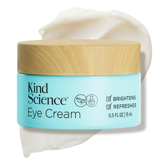 Kind Science Eye Cream jar with wooden cap on a white background with a swatch of the product