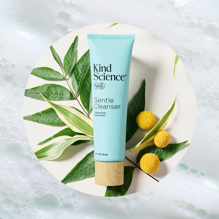 Kind Science Gentle Cleanser tube on a bed of chamomile and Kakadu Plum leaves